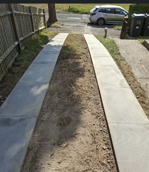 Two concrete wheel-track strips laid along a side access