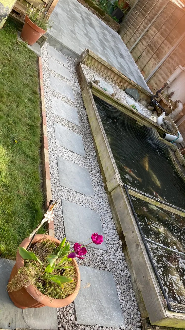 Stepping-stone slab path set in gravel beside a raised bed