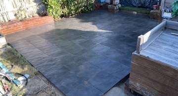 Dark slate-effect patio in a rear garden